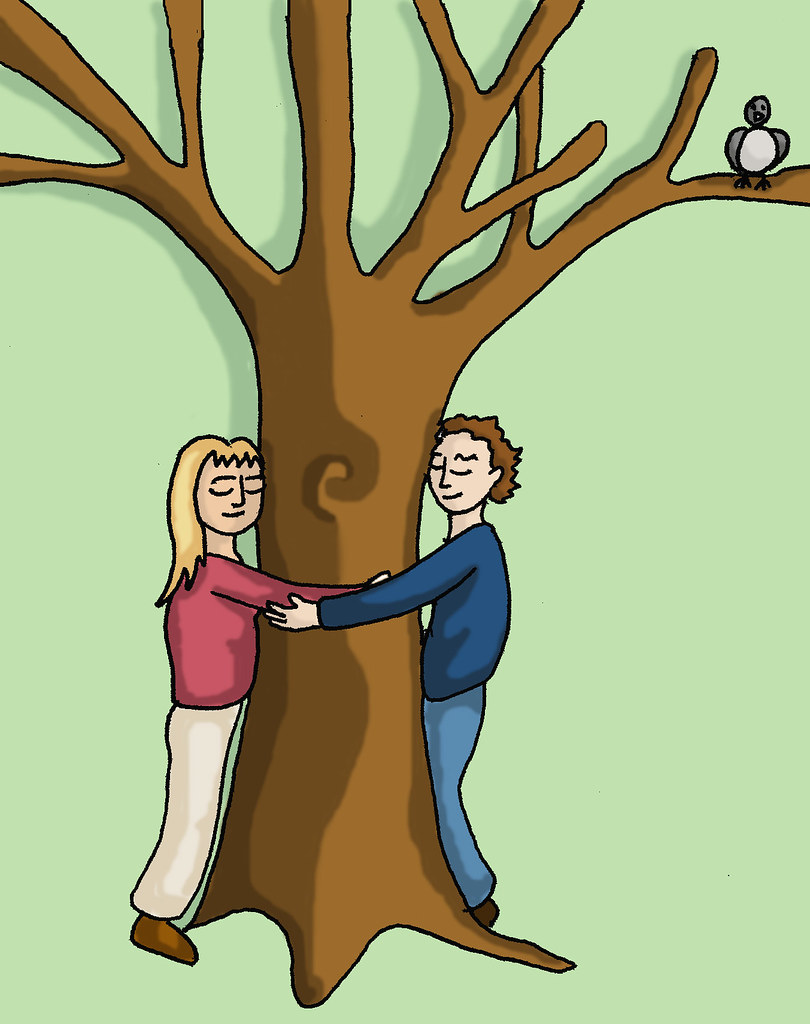 A man and womrn hugging a tree